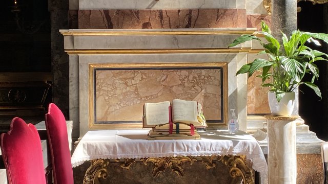 Open bible next to a bottle of hand sanitiser