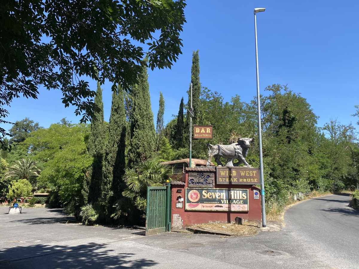 Entrance to Seven Hills Village resort with a concrete bull above a sign for the Wild West Steak House