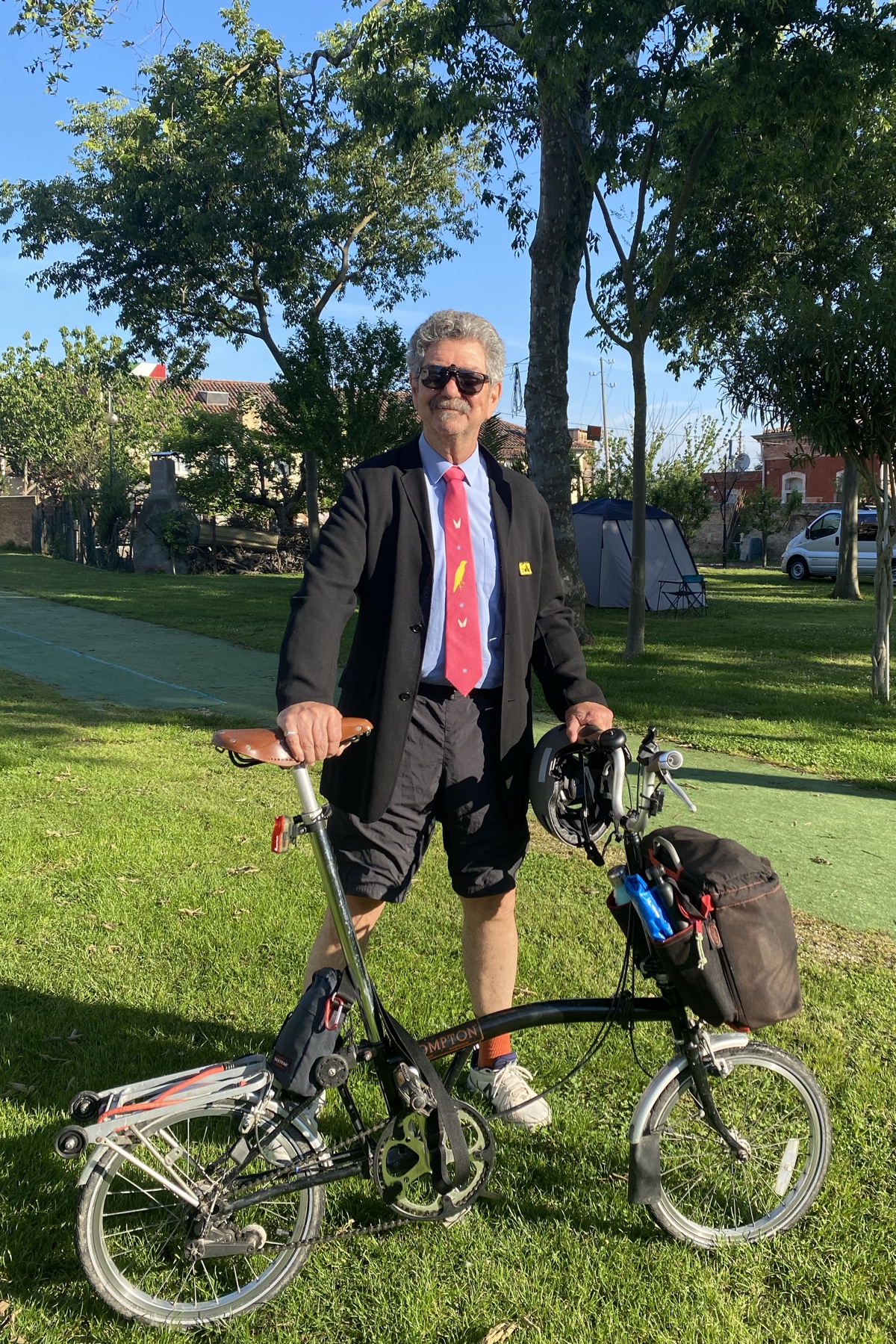 Me, dressed up in black jacket, blue shirt, pink Craig Aitchison tie, and shorts for the Brompton World Championships and holding my fine old Brompton five-speed.